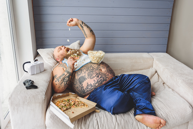 Lazy fat man eating unhealthy food