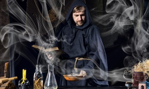 術・Halloween magician is preparing for a magical ritual in ancient table