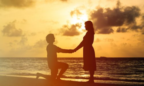 愛・Silhouette of a young romantic couple at sunset beach